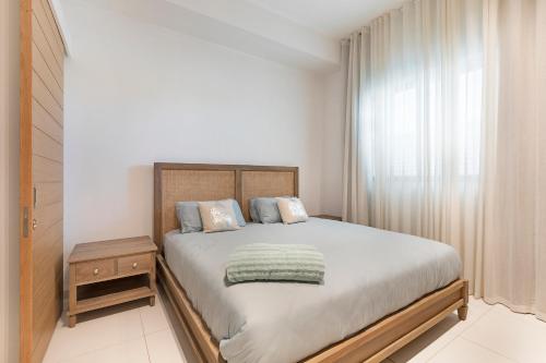 ein Schlafzimmer mit einem großen Bett und einem Fenster in der Unterkunft Ki Residence in Grand Baie