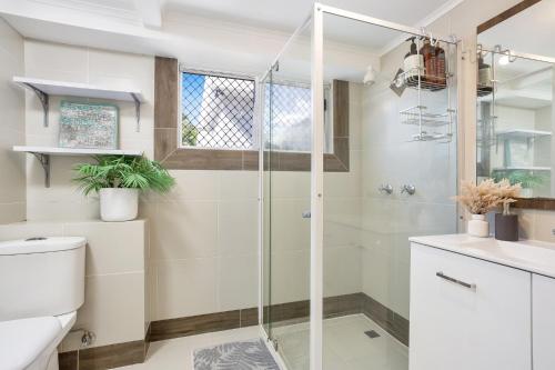 ein Bad mit einer Dusche und einem WC in der Unterkunft Seaside Serenity Modern Cottage with Spa in Machans Beach