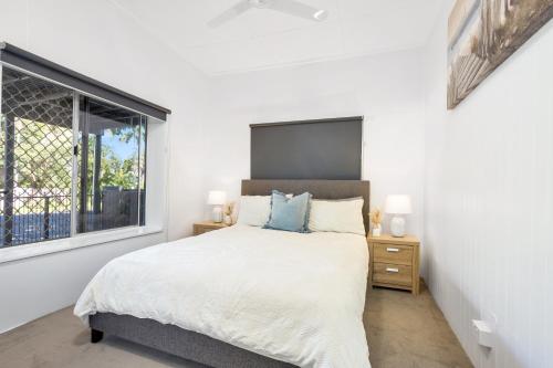 ein Schlafzimmer mit einem großen Bett und einem Fenster in der Unterkunft Seaside Serenity Modern Cottage with Spa in Machans Beach