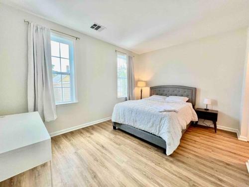 a white bedroom with a bed and a window at UPSCALE Condo Near NYC, MetLife & American Dream in Passaic