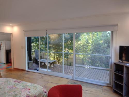een kamer met een grote glazen schuifdeur en een balkon bij El parquecito in Tandil