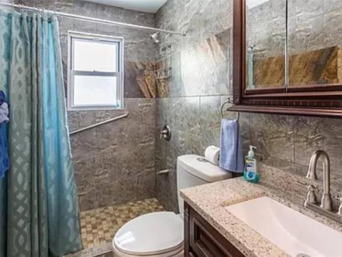 a bathroom with a toilet and a sink and a shower at Lovely 1 Bedroom Unit Across from Lido Key Beach in Sarasota