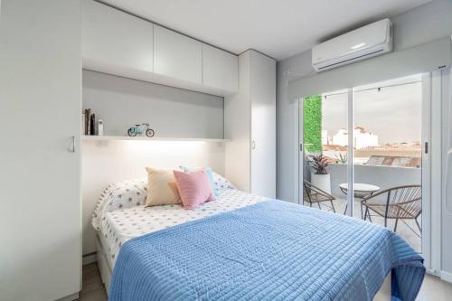 Schlafzimmer mit einem Bett mit blauer Decke in der Unterkunft Mv depa - Unico y exclusivo departamento en el centro de Córdoba in Cordoba