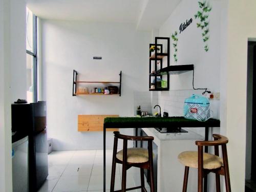 a kitchen with a counter and two stools at Rumah Kembar DI kawasan wisata lembang in Citeureup 1