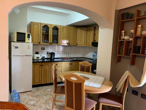 cocina con mesa y nevera blanca en Ferienwohnung Durres Albania en Durrës