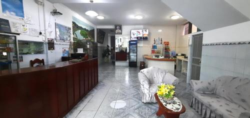 un vestíbulo de una farmacia con barra y sillas en Hostal Las Palmeras, en Jaén