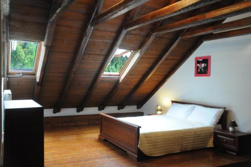 a bedroom with a bed in a room with wooden ceilings at Giusvalla Forest Village in Dego