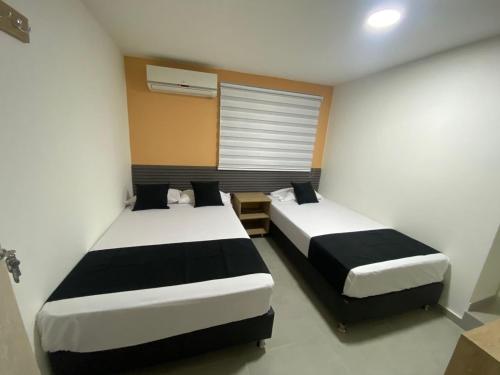 a room with two beds and a window at HOTEL ESTADIO DORADO in Medellín