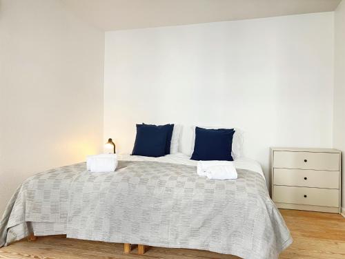 a bedroom with a large bed with blue pillows at 1 Bedroom Apartment In Kolding City Center in Kolding