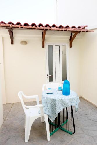 a table and two chairs with a blue item on it at Maria Studios & Apartments in Kremasti