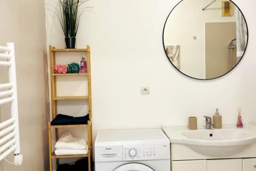 a bathroom with a sink and a washing machine at Penthouse de standing: Vue paris- 10min de l'aéroport Orly - Parking gratuit in Orly