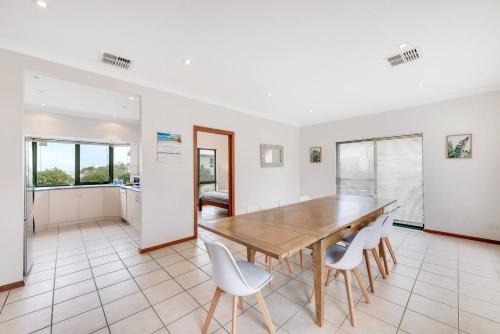 a dining room with a wooden table and white chairs at 10 Rupara - Linen Included in Hayborough