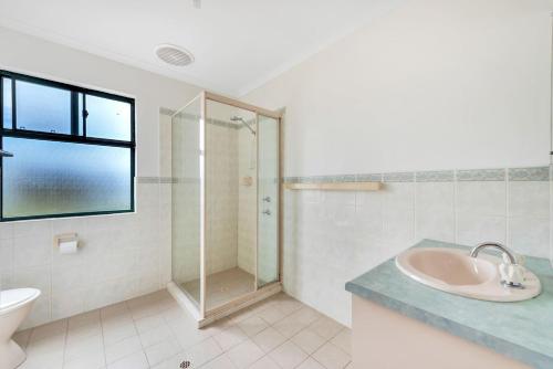 a bathroom with a sink and a glass shower at 10 Rupara - Linen Included in Hayborough