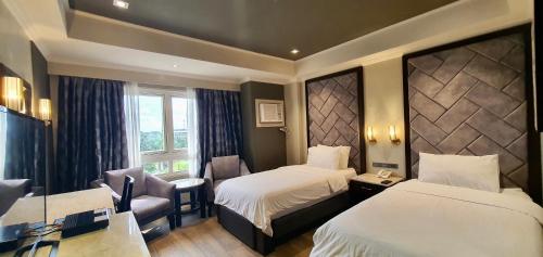 um quarto de hotel com duas camas e uma janela em MO2 Westown Hotel Iloilo em Iloilo