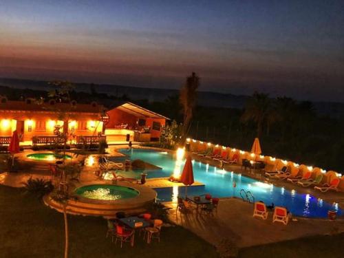 a swimming pool with a lot of chairs and lights at Tunis Pyramids Hotel - فندق اهرامات تونس in Tunis