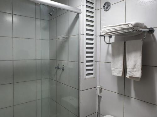 een badkamer met een douche en een glazen douchedeur bij Gran Lençóis Flat Residen in Barreirinhas