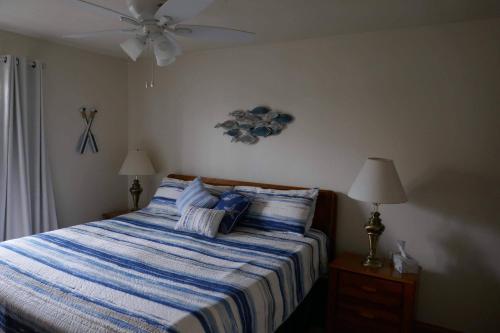 ein Schlafzimmer mit einem Bett mit einer blau-weißen gestreiften Decke in der Unterkunft Emerald Bay Yacht Club G-4 in Hollister