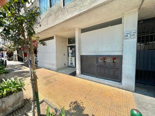 a building with a large garage door on a sidewalk at Departamento Cómodo y Luminoso in Santiago