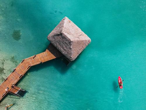 eine Luftansicht auf einen Pier im Wasser mit einem Boot in der Unterkunft Khaban Bacalar Hotel Boutique in Bacalar