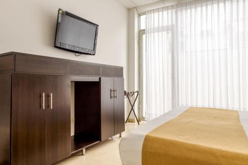 a bedroom with a bed and a flat screen tv on the wall at Hotel Manantial Melgar Torre 2 in Melgar