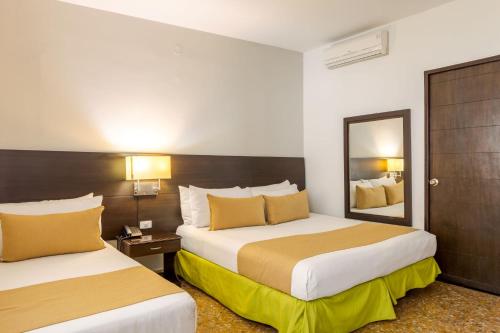 梅爾加的住宿－Hotel Manantial Melgar Torre 2，酒店客房,设有两张床和镜子
