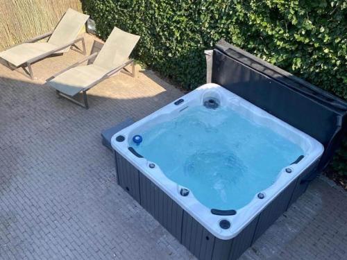 une baignoire jacuzzi avec une chaise et une chaise dans l'établissement Villa with pool sauna and bubble bath, à Looz