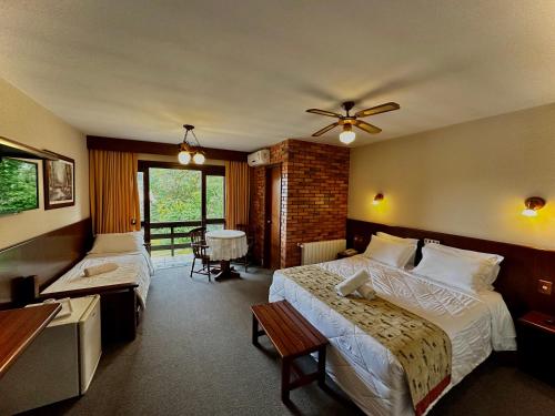 Natur Hotel في غرامادو: غرفة فندقية بسريرين وطاولة