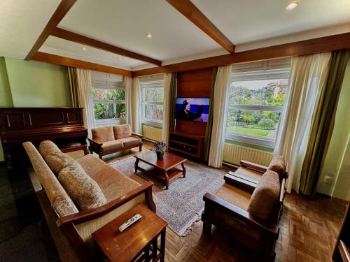 a living room with a couch and a tv at Natur Hotel - 700m da Rua Coberta in Gramado