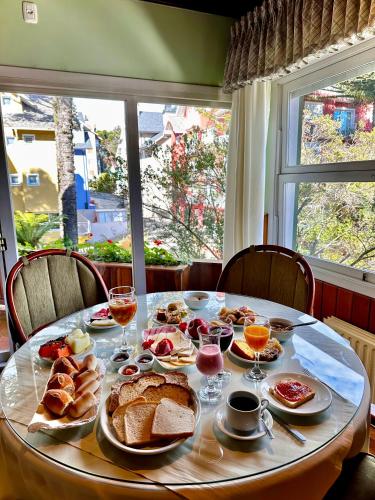 a table with breakfast food on it with a window at Natur Hotel - 700m da Rua Coberta in Gramado