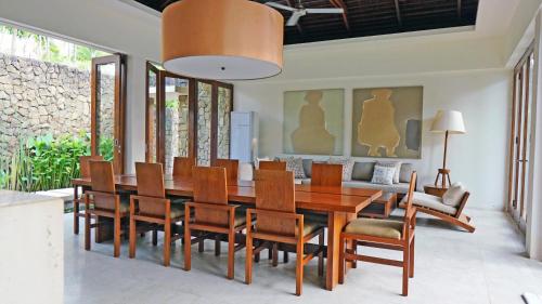 una sala da pranzo con tavolo e sedie in legno di The New Villa Suar a Seminyak