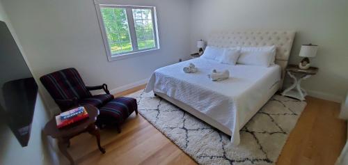 a bedroom with a bed and a chair and a window at Hilltop Mansion at Rebecca's Fountain 