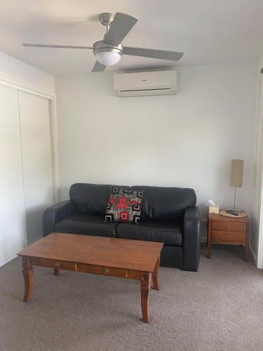 a living room with a black couch and a coffee table at Bundalong Villas in Bundalong