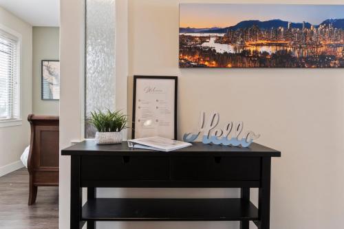 a black desk in a room with a painting on the wall at 3 bed, 2 bath upper suite overlooking the city in Vernon