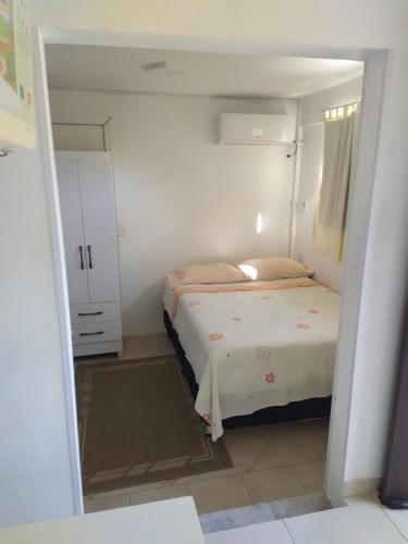 Un pequeño dormitorio con una cama y un pequeño armario en Sossego da ilha, en Florianópolis
