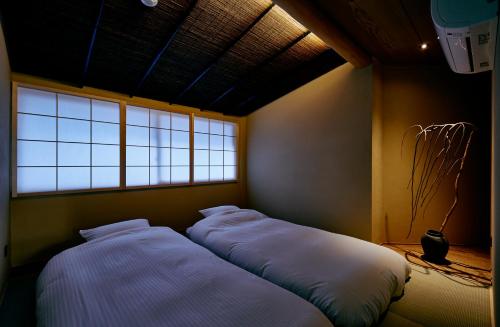 - 2 lits dans une chambre avec fenêtre dans l'établissement ANJIN Gion Shirakawa, à Giommachi