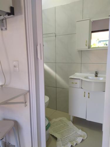 Baño blanco con lavabo y aseo en Sossego da ilha, en Florianópolis