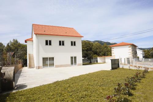 a white house with a yard in front of it at Casa Vilar in Ponte de Lima