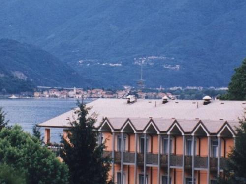 ヴェルバーニアにあるApartment in a residence on Lake Maggiore near the beachの大屋根の水の横にある大きな建物