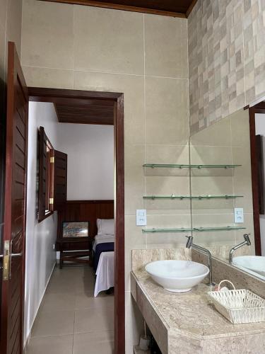 a bathroom with a sink and a mirror and a bed at Casa da Serra Negra in Bezerros