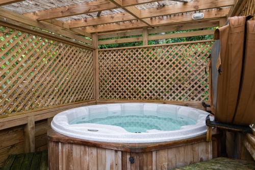 eine Whirlpool-Badewanne in einem Bambushaus in der Unterkunft Blue Lake TOP 10 Holiday Park in Rotorua