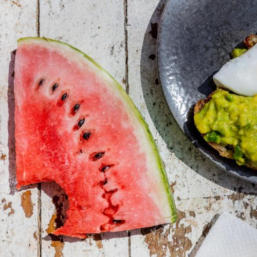 a watermelon cut in half next to a bowl of guacamole at Tatajuba Hostel Casa Pascual in Tatajuba