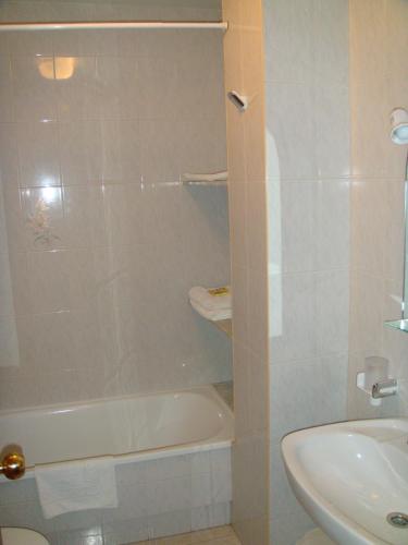 a bathroom with a tub and a toilet and a sink at Hotel Vimar in Sanxenxo