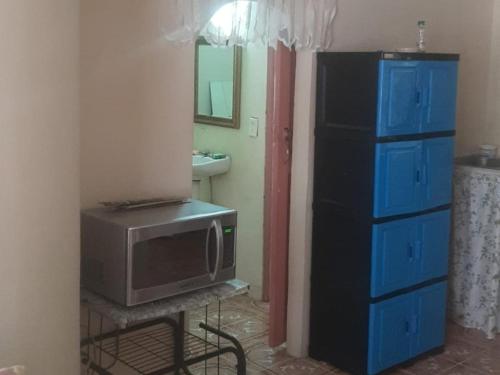 a bathroom with a tv and a dresser with a mirror at Hospedaje la subidita 1 in Colón