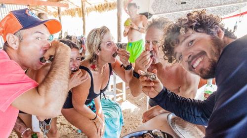 a group of people eating food on the beach at Tatajuba Hostel Casa Pascual in Tatajuba