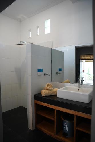 ein Bad mit einem Waschbecken und einem Spiegel in der Unterkunft Rasti 2 homestay in Kuta Lombok