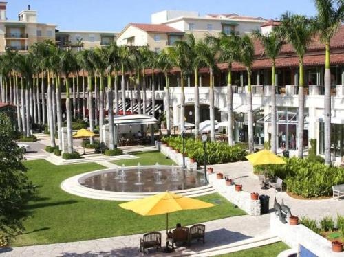 a resort with a courtyard with a fountain and palm trees at My Nautical Paradise in Miami in Miami