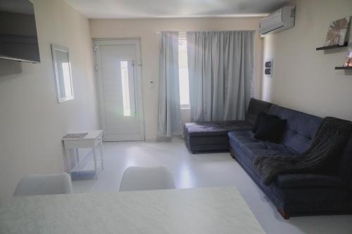 een woonkamer met een bank en een tafel bij Pavia's Centerpoint Oasis in Oranjestad