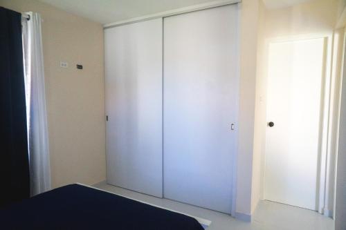 a bedroom with a white closet and a door at Pavia's Centerpoint Oasis in Oranjestad