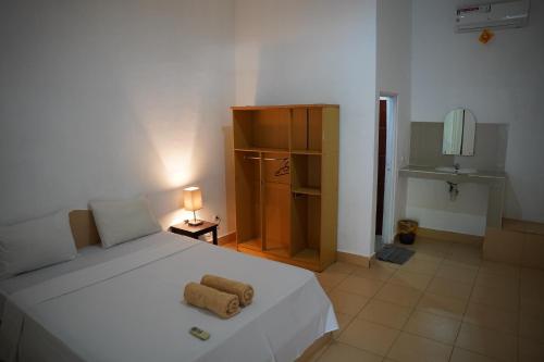 a bedroom with a white bed with two towels on it at Rasti 2 homestay in Kuta Lombok