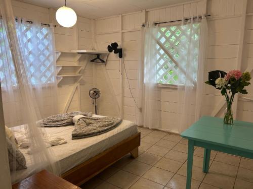 a bedroom with a bed and a table and a window at White Son house, a pasos de la playa, 50MG WIFI in Punta Uva